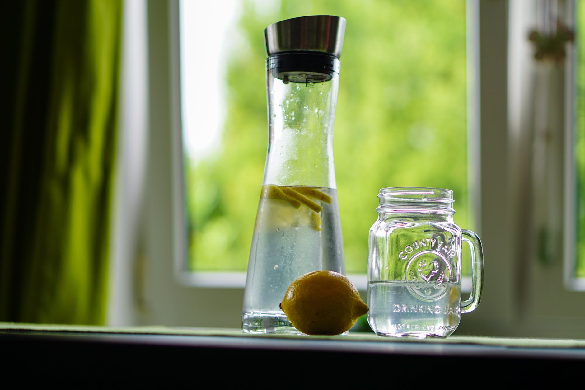 shallow focus photography of yellow lemon near glass mason jar and glass decanter